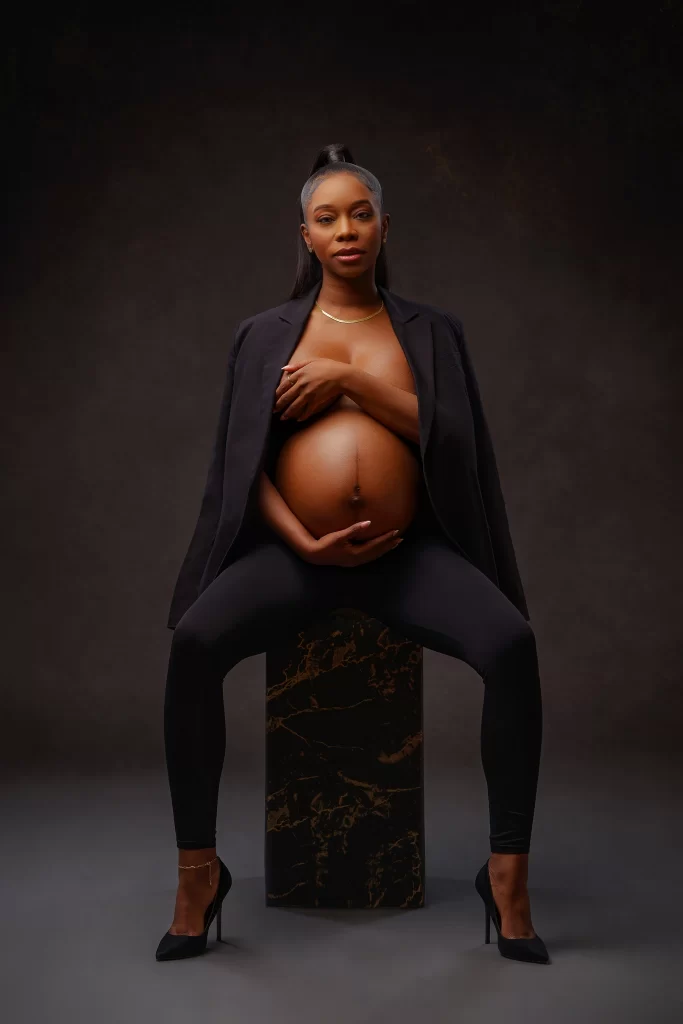 A maternity photoshoot featuring a women wearing a suit jacket.
