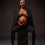 A maternity photoshoot featuring a women wearing a suit jacket.